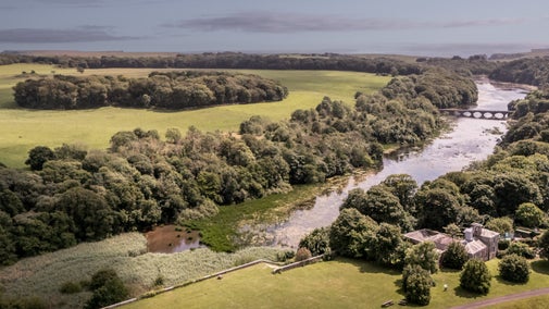 An aerial view of Cawdor and Stackpole's lakes and parkland beyond, leading to the sea, Pembrokeshire